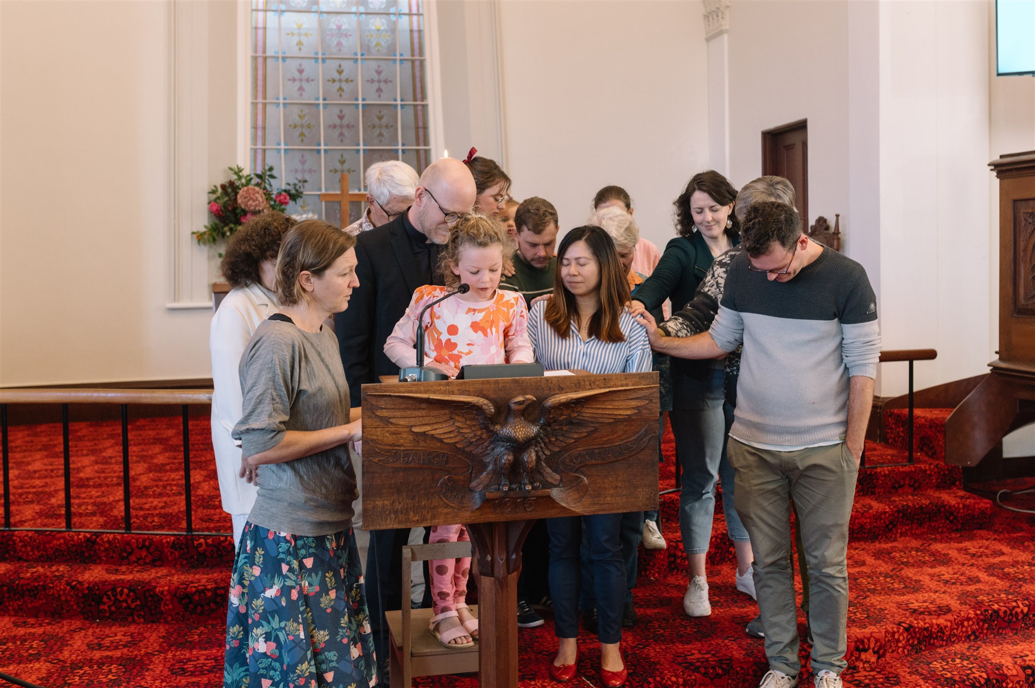 A group praying over someone at the pulpit