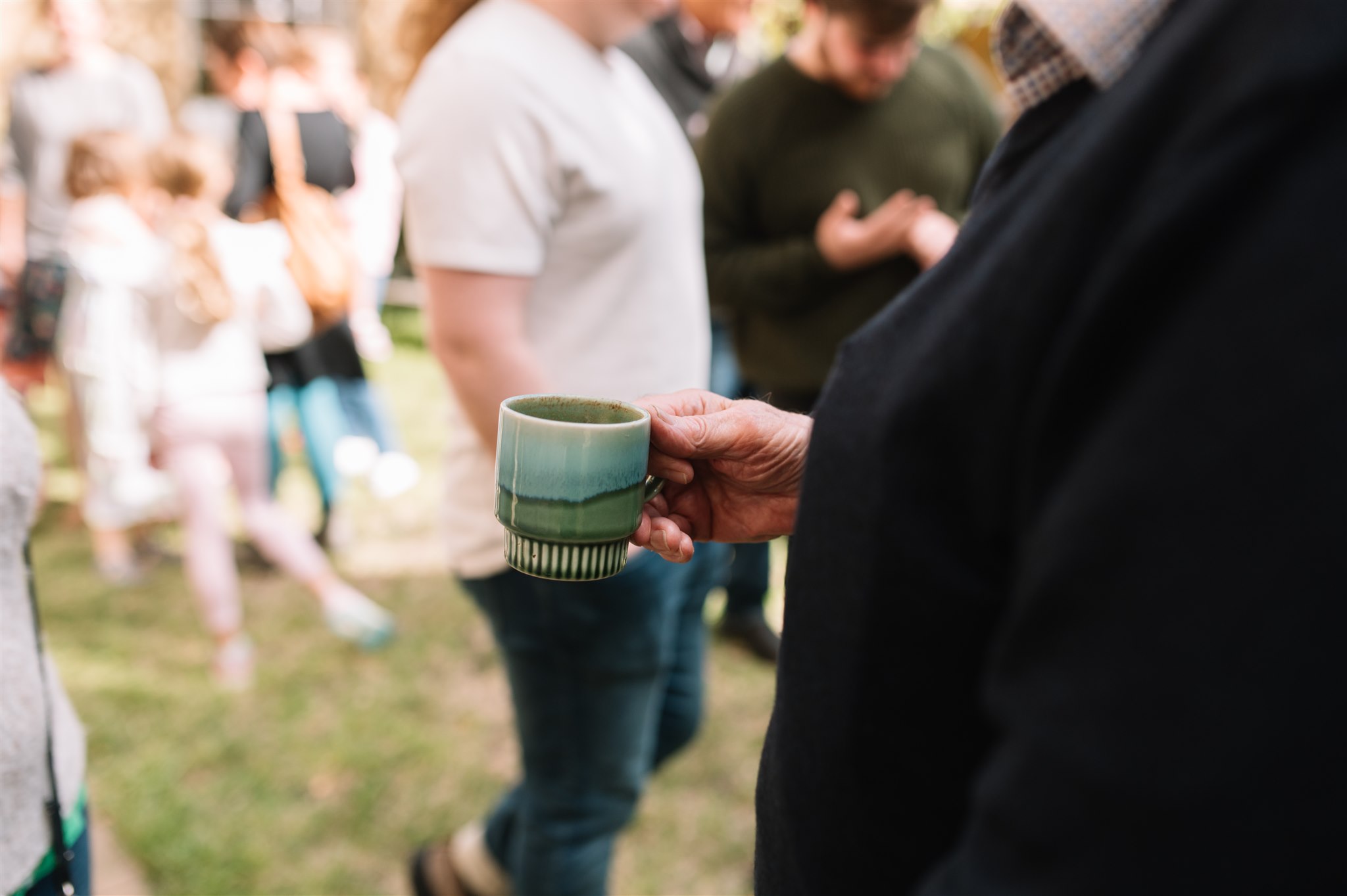 A senior congregation member drinking a coffee
